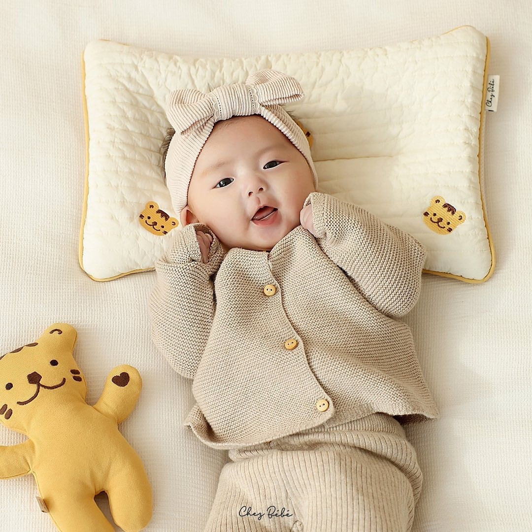 Almohada bordada para dar forma a la cabeza plana de los bebés